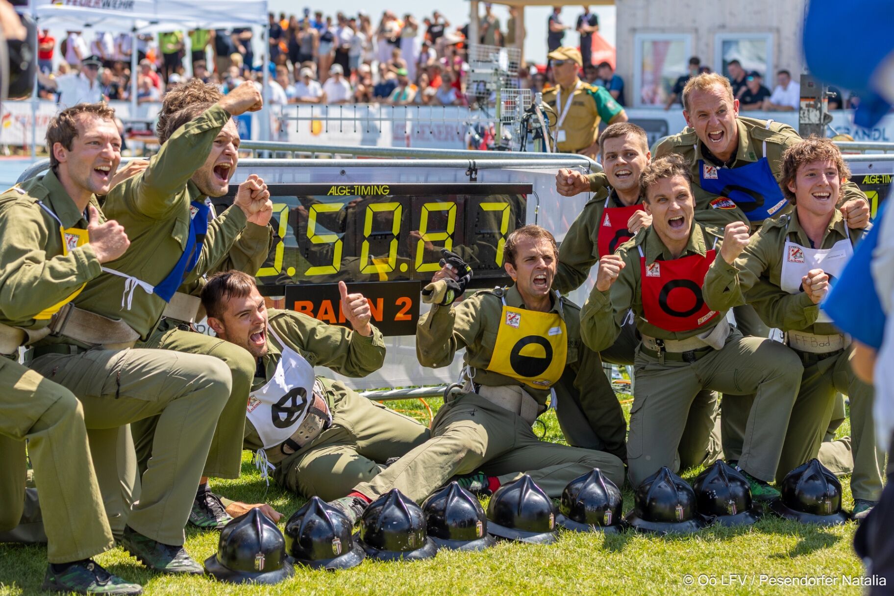 Jubelnde Feuerwehrmannschaft beim Bewerb vor der Zeittafel