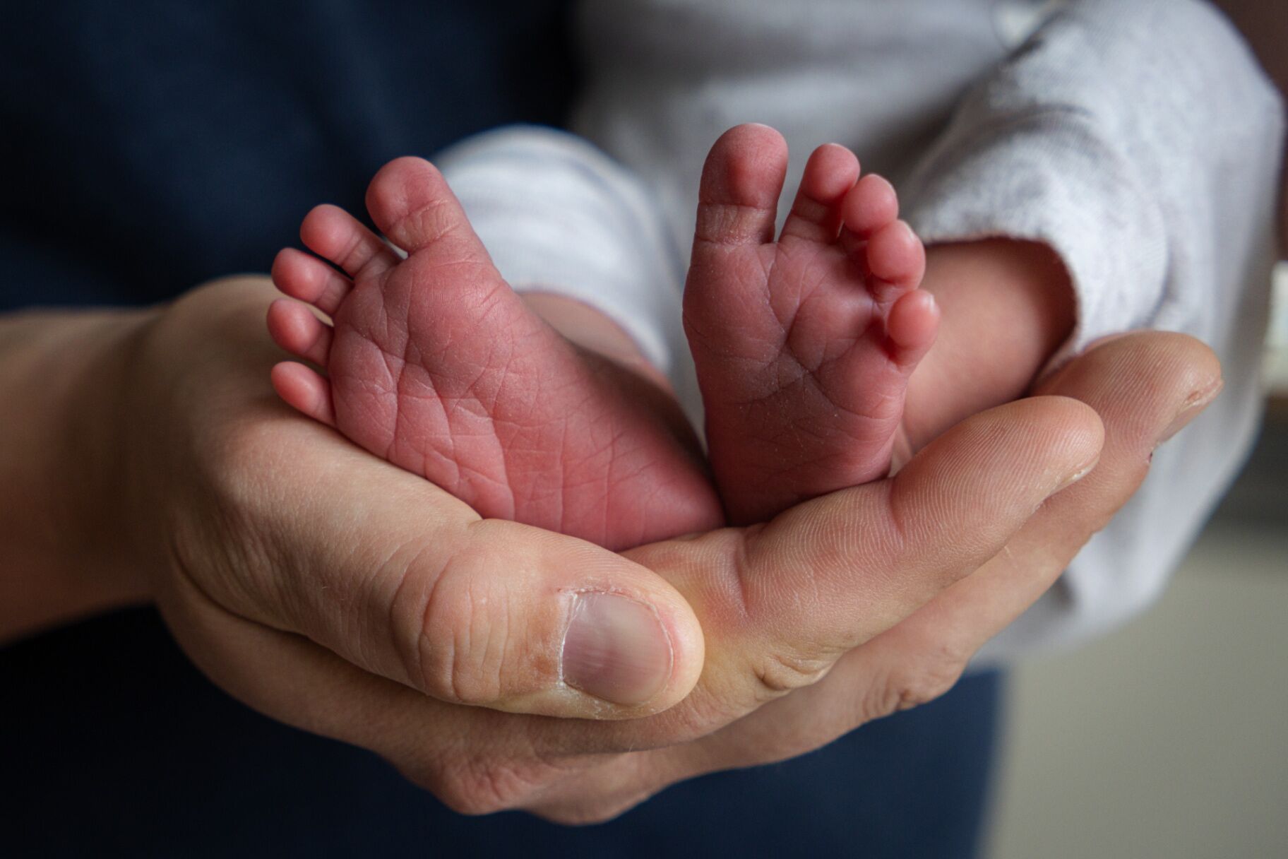 Babyfüße in den Händen der Eltern